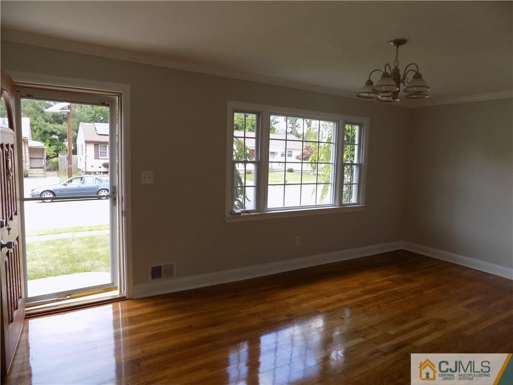 152 Orange Street Edison, NJ 08817 - Photo 8 of 23 a view of an empty room with wooden floor and a window