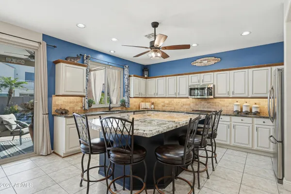 a kitchen with stainless steel appliances granite countertop a sink and a refrigerator
