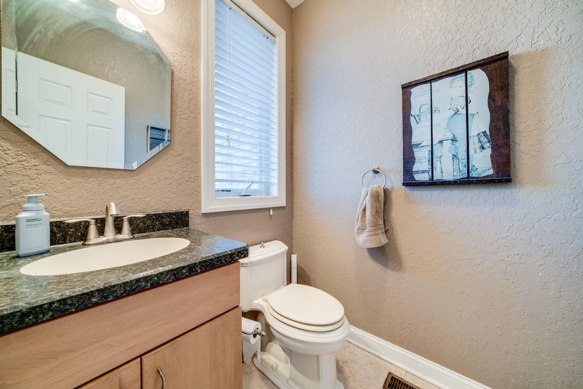 4092 West Pond Road Leaf River, IL 61047 - Photo 15 of 71 a bathroom with a granite countertop toilet sink and mirror