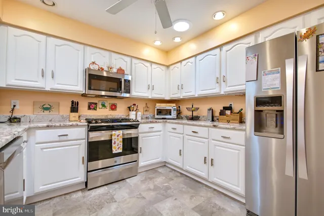 a kitchen with stainless steel appliances granite countertop a stove and cabinets