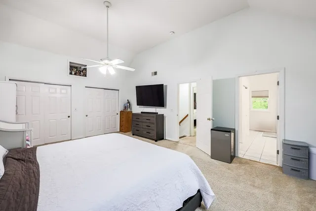 a large bedroom with a bed and a flat screen tv