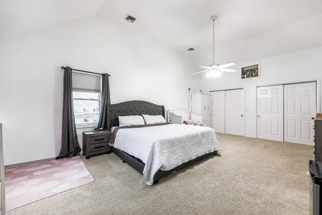 a bedroom with a bed chandelier and a window