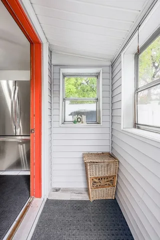 a view of an entryway door with a chair and a potted plant