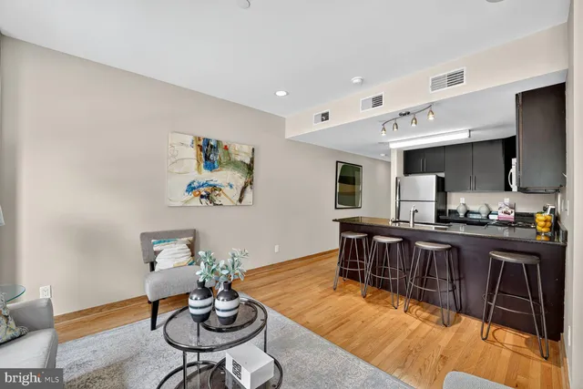 a living room with furniture a dining table and chairs with kitchen view