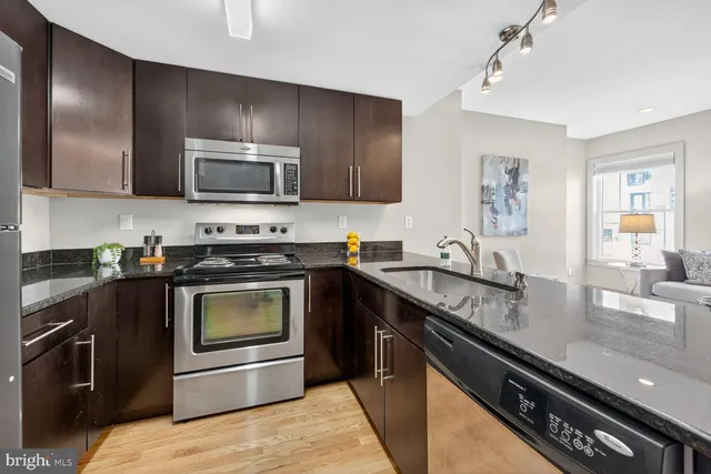 a kitchen with granite countertop stainless steel appliances and wooden cabinets