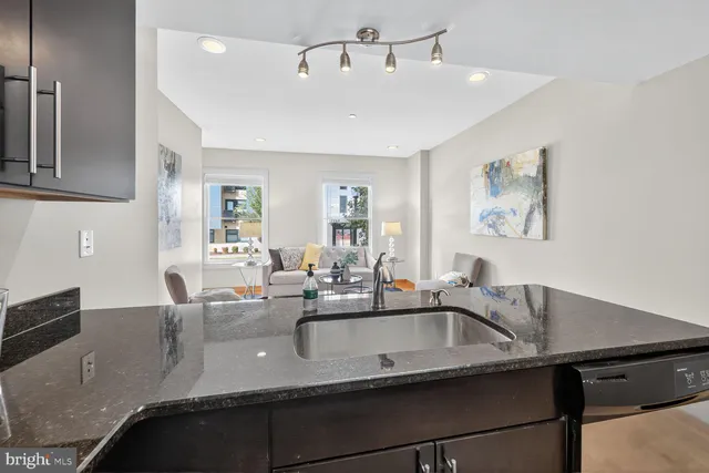 a kitchen with a sink a counter space and chandelier