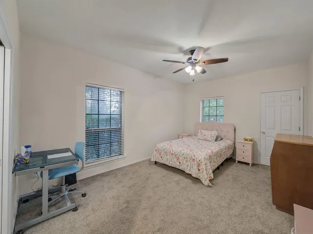 a spacious bedroom with a bed and a chandelier