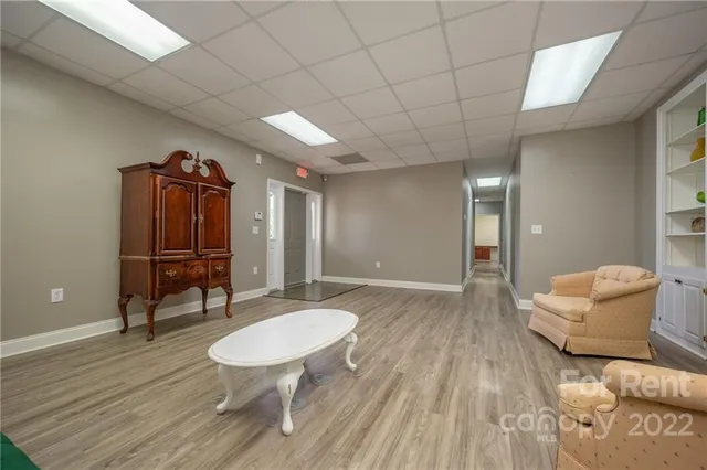 a living room with furniture a table and wooden floor