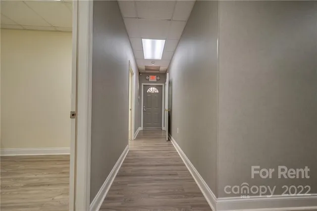 a view of a hallway with wooden floor