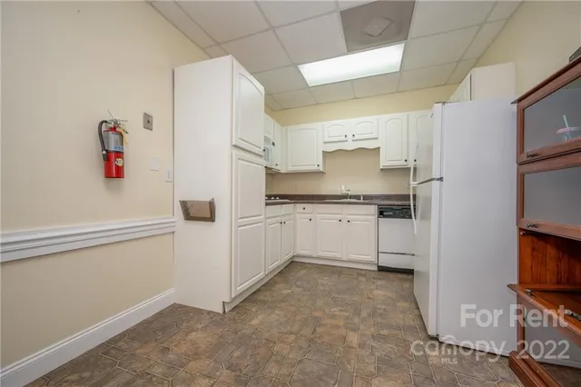 a kitchen with white cabinets and white appliances