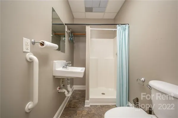 a bathroom with a sink a toilet and shower