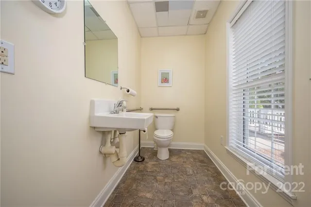 a bathroom with a sink a toilet and mirror