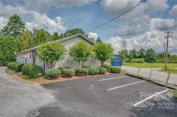 a view of a house with a yard and potted plants