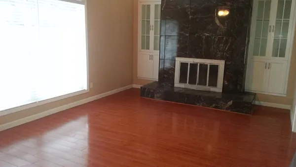 a view of a livingroom with wooden floor and a window
