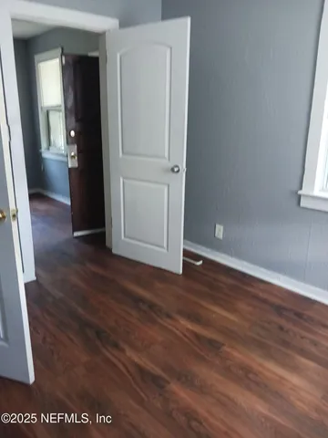 an empty room with wooden floor and closet
