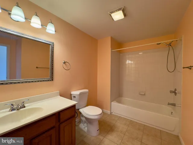 a bathroom with a granite countertop sink a toilet and shower