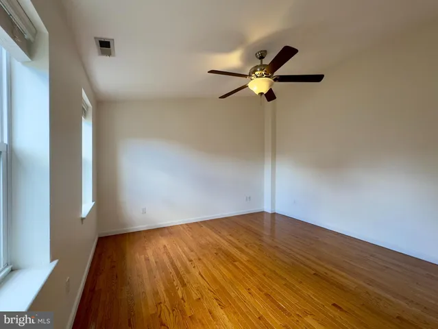 a view of empty room with wooden floor