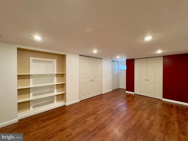a view of an empty room with a wooden floor and a window