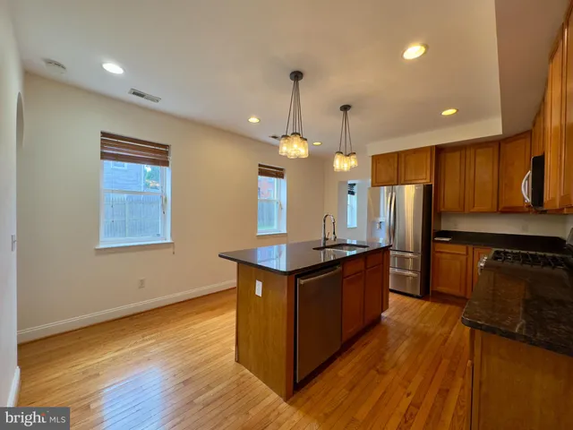 a kitchen with stainless steel appliances granite countertop a stove a sink dishwasher and a refrigerator