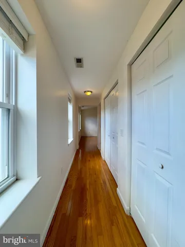 a view of a hallway with wooden floor