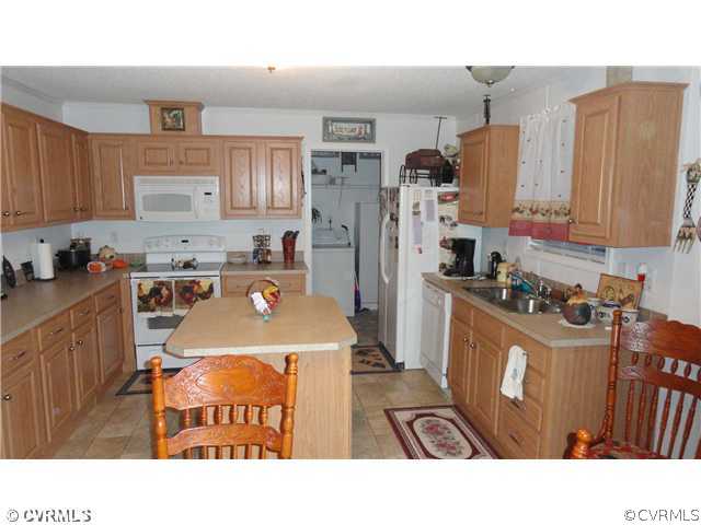 17206 Hamilton Arms Road Dewitt, VA 23840 - Photo 3 of 12 a kitchen with stainless steel appliances kitchen island granite countertop a refrigerator a kitchen island a stove a sink dishwasher and white cabinets with wooden floor