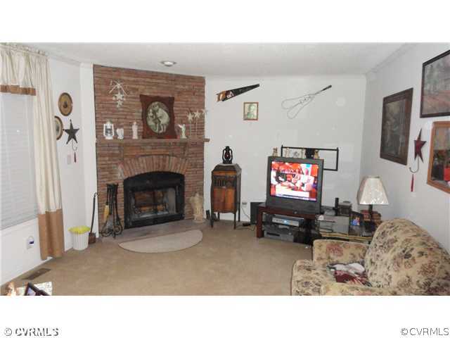 17206 Hamilton Arms Road Dewitt, VA 23840 - Photo 5 of 12 a living room with furniture a fireplace and a flat screen tv