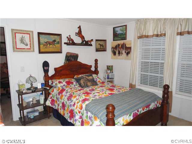 17206 Hamilton Arms Road Dewitt, VA 23840 - Photo 6 of 12 a bedroom with a bed and wooden floor