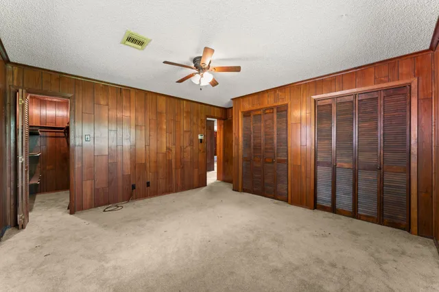 a view of an empty room with a ceiling fan