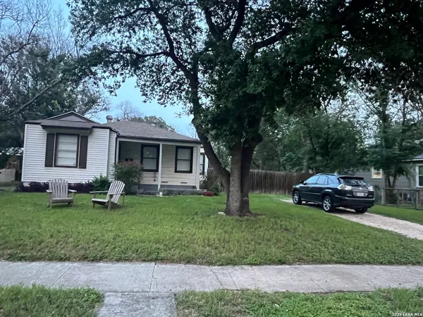 a front view of a house with a garden and trees