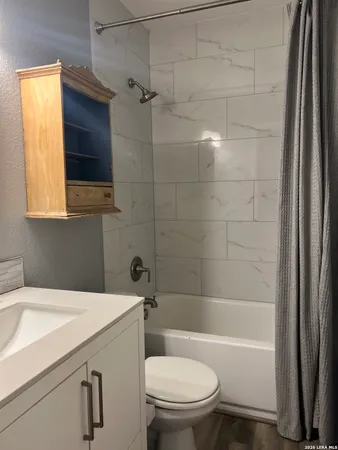 a bathroom with a sink a toilet and shower