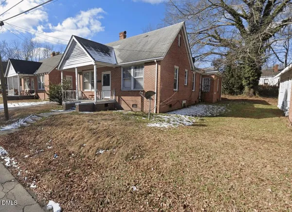 a view of a house with a yard and large tree