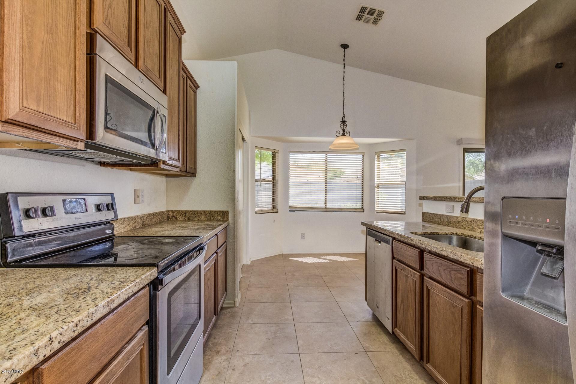 2129 West Carson Road Phoenix, AZ 85041 - Photo 3 of 22 a kitchen with stainless steel appliances granite countertop a stove a sink and a microwave
