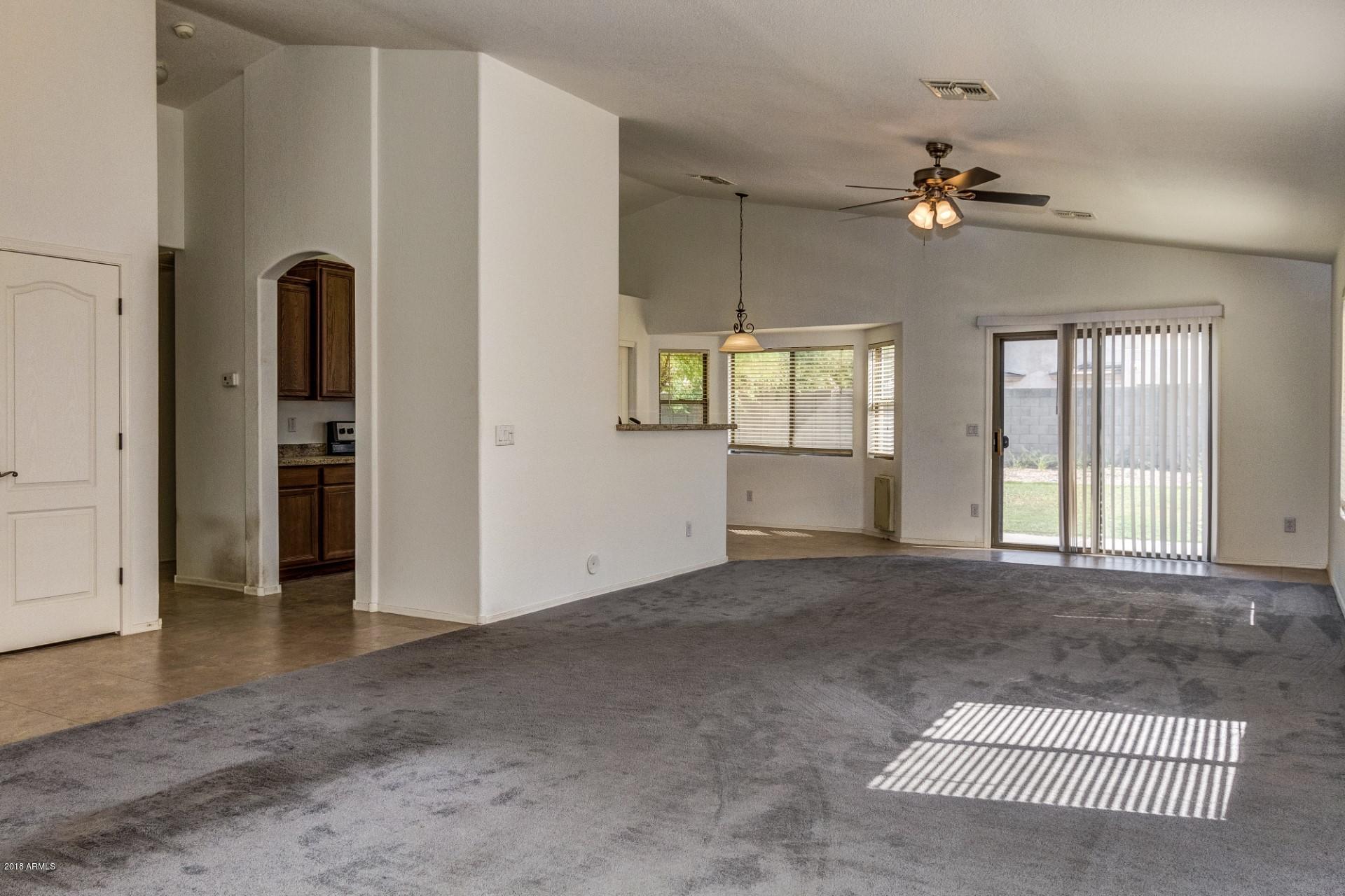 2129 West Carson Road Phoenix, AZ 85041 - Photo 8 of 22 an empty room with windows and ceiling fan