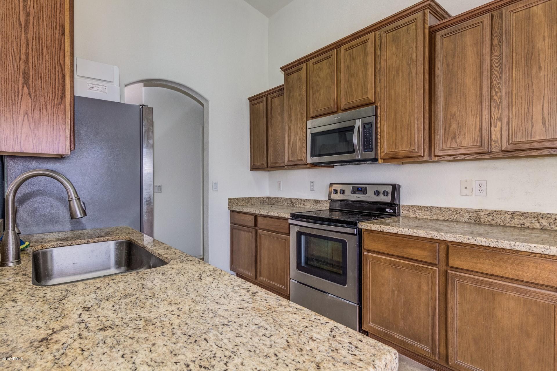2129 West Carson Road Phoenix, AZ 85041 - Photo 9 of 22 a kitchen with granite countertop a stove sink and microwave