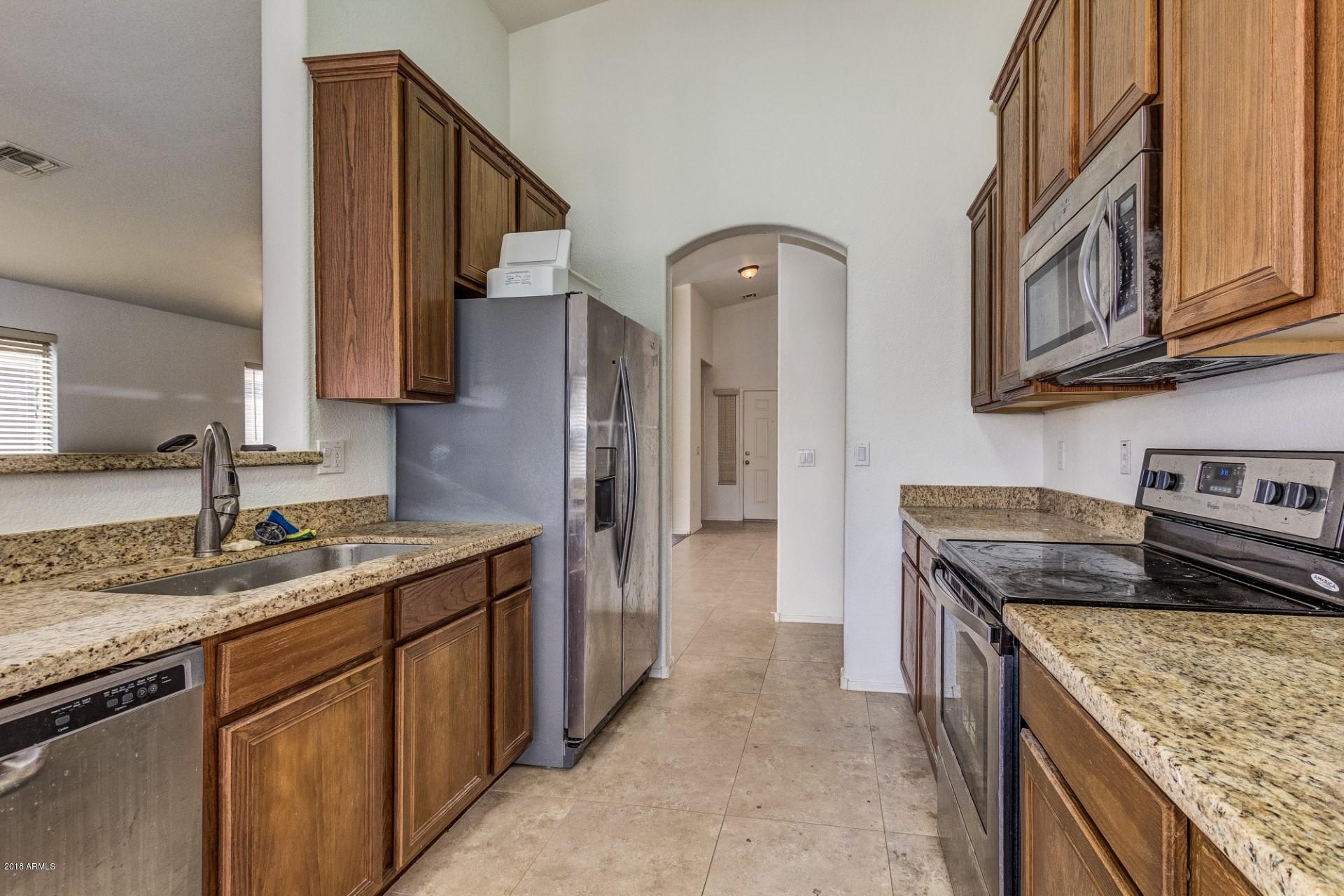 2129 West Carson Road Phoenix, AZ 85041 - Photo 10 of 22 a kitchen with stainless steel appliances granite countertop a sink stove and cabinets
