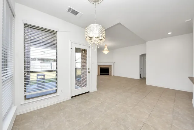 a view of a livingroom with a chandelier fan and windows