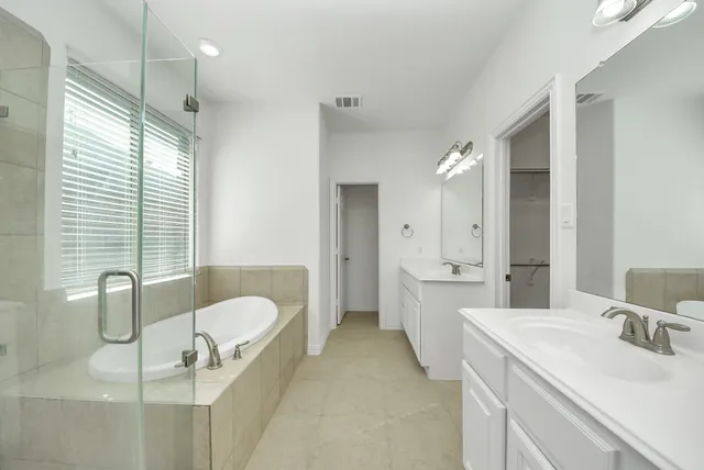 a bathroom with a granite countertop sink mirror and bathtub