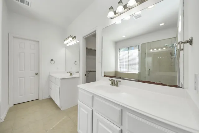 a bathroom with a sink a large mirror and shower