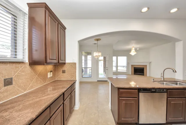 a kitchen with granite countertop a sink and a stove