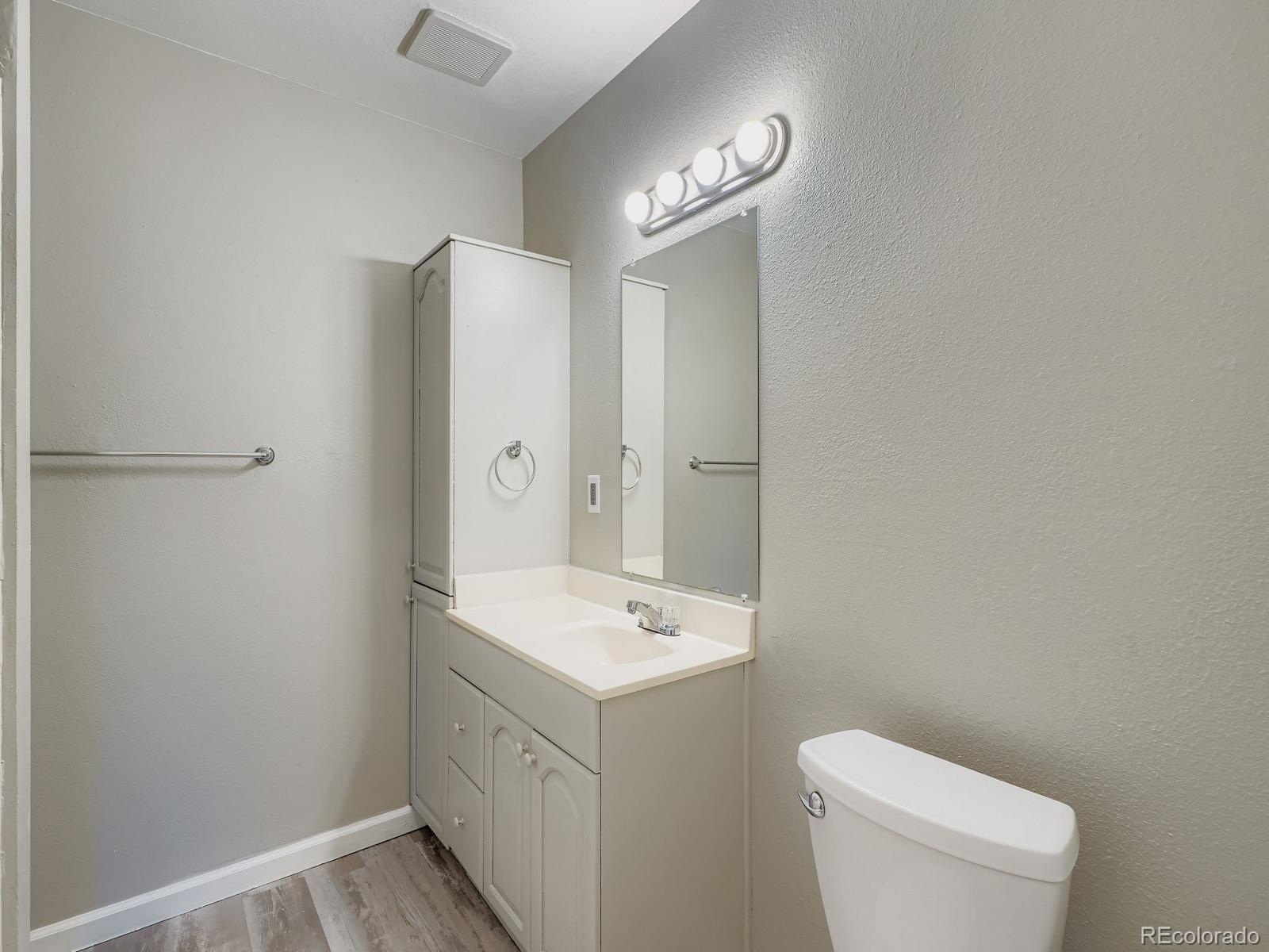 140 East Highline Circle, Unit 105 Centennial, CO 80122 - Photo 12 of 29 a bathroom with a toilet a sink a mirror and vanity