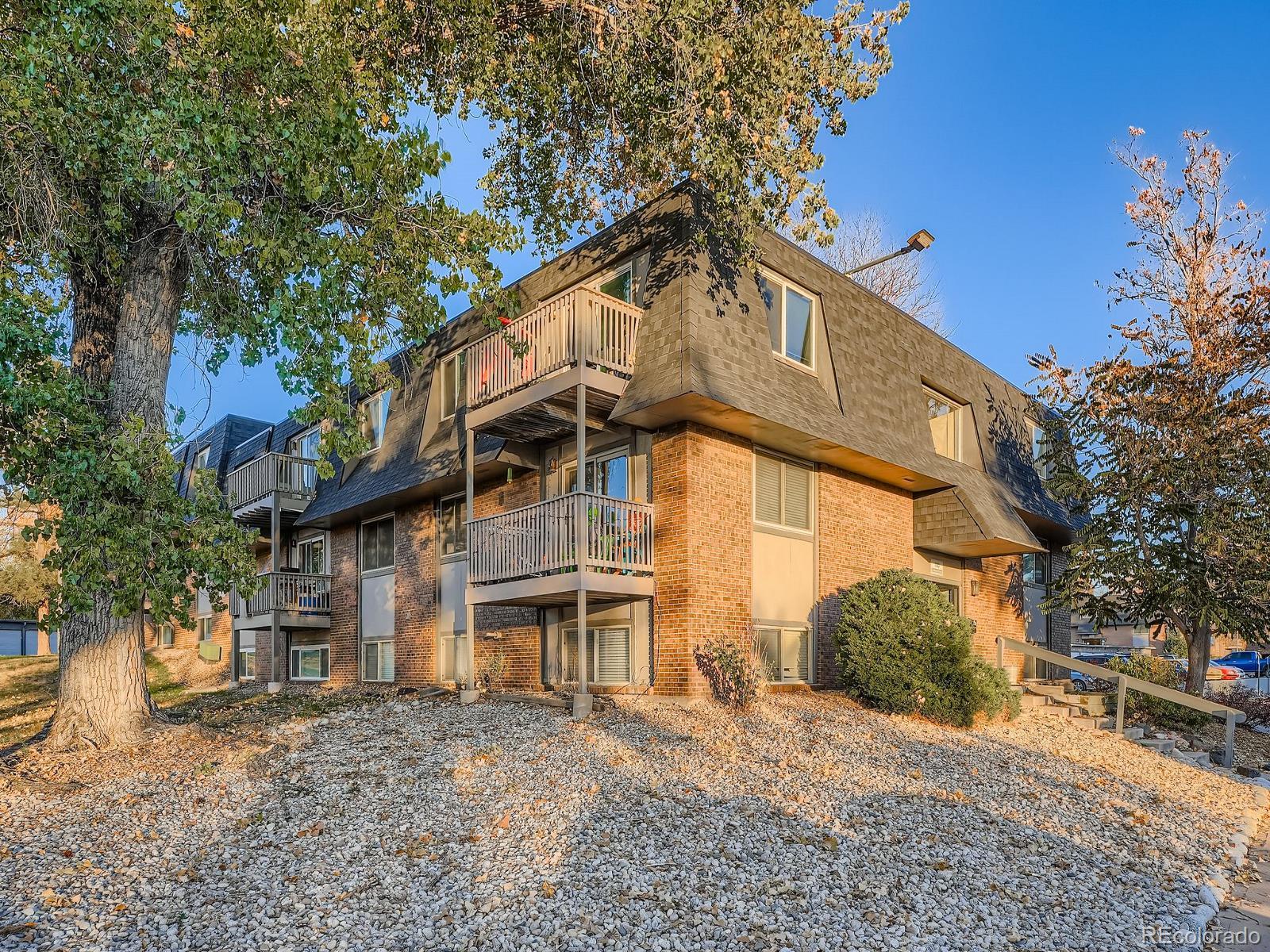 140 East Highline Circle, Unit 105 Centennial, CO 80122 - Photo 3 of 29 a view of a white house with large windows and a tree