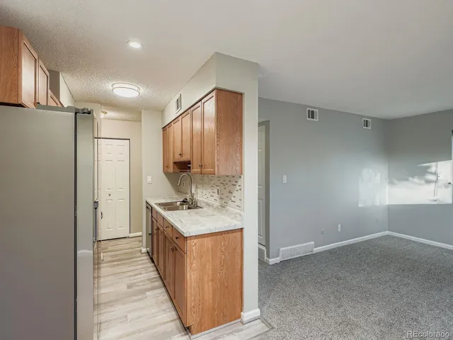 a kitchen with a sink a refrigerator and cabinets