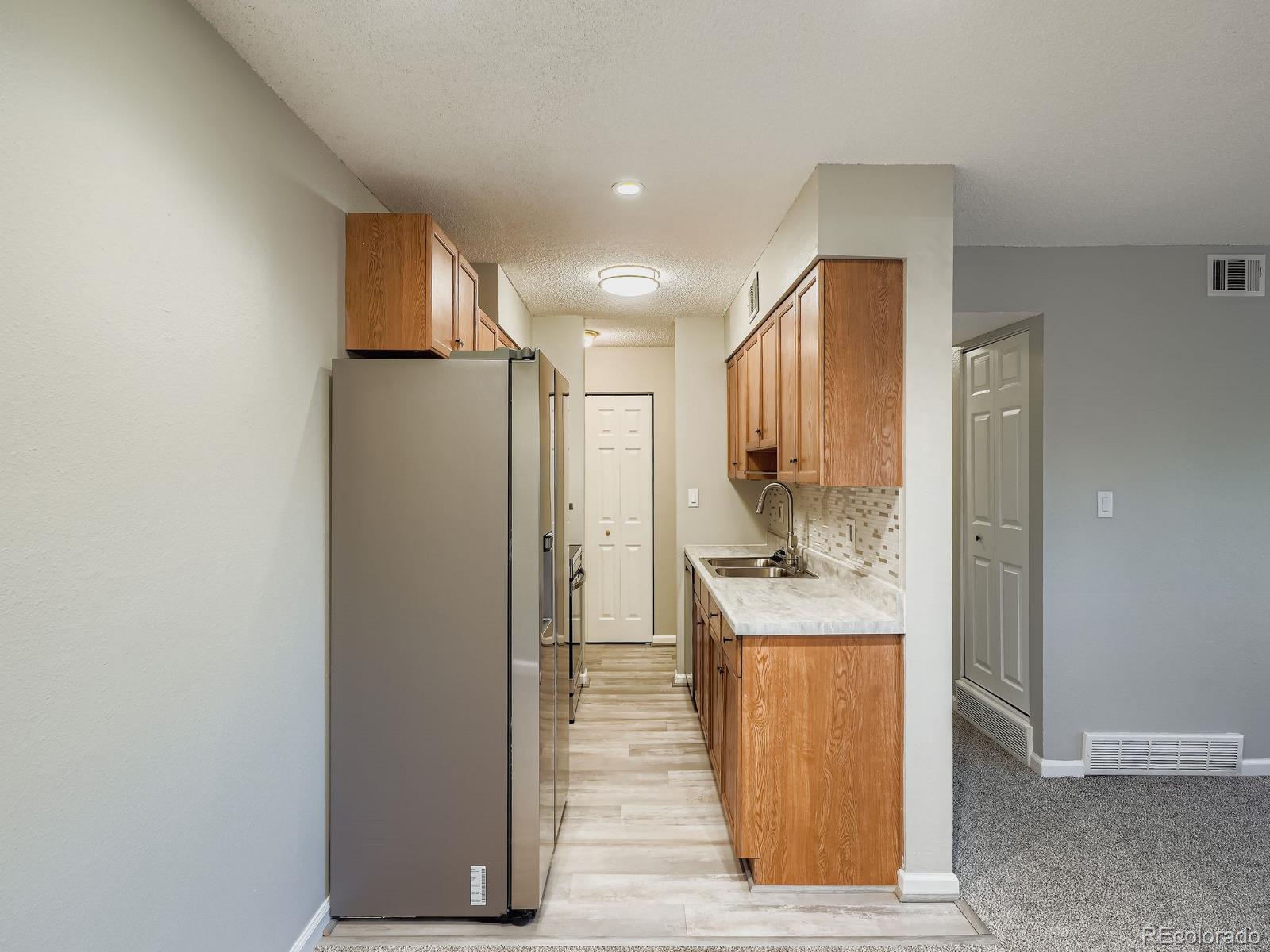 140 East Highline Circle, Unit 105 Centennial, CO 80122 - Photo 7 of 29 a kitchen with stainless steel appliances granite countertop a refrigerator a sink and a stove