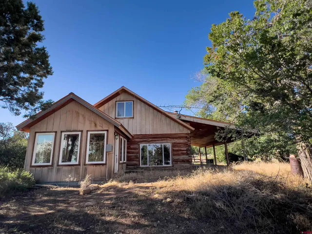 a front view of a house with yard and trees