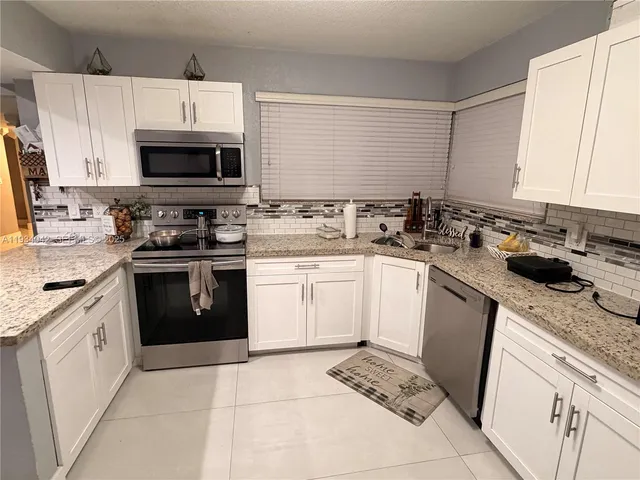 a kitchen with a sink stove top oven and cabinets