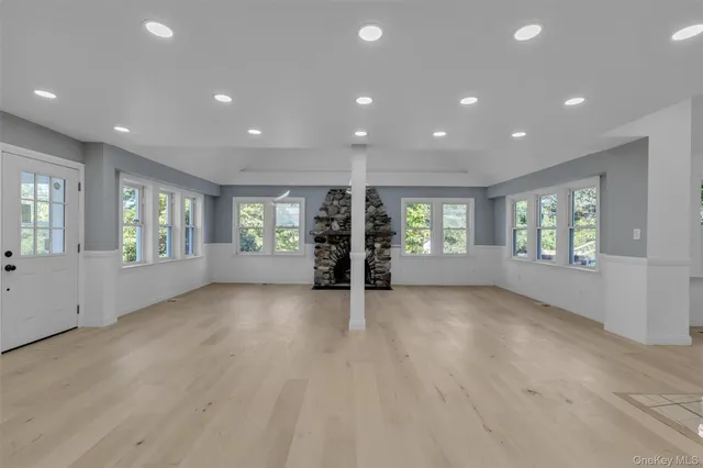 an empty room with window and wooden floor