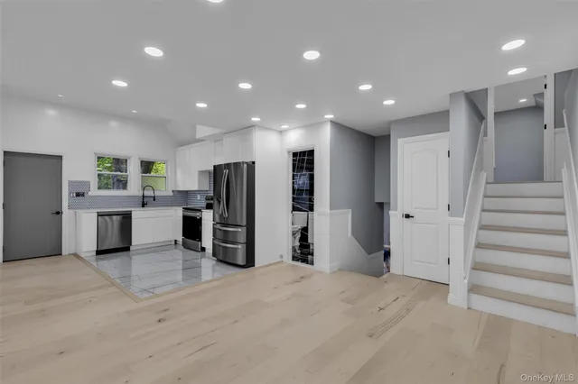 a view of a kitchen with refrigerator and chairs