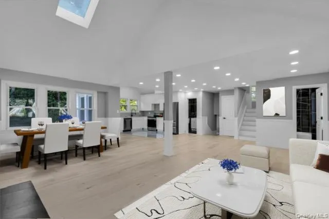 a living room with furniture a wooden floor and kitchen view