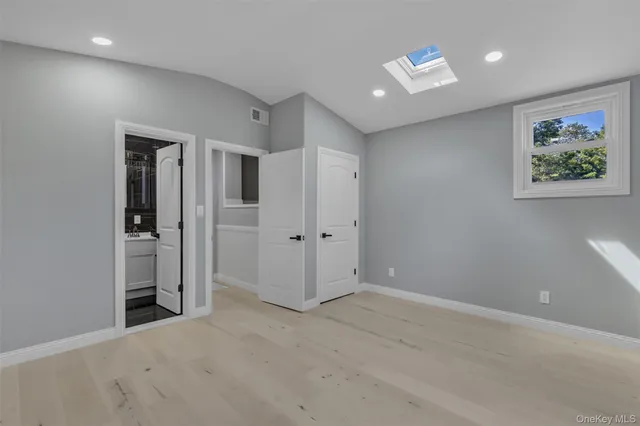 an empty room with closet and a window