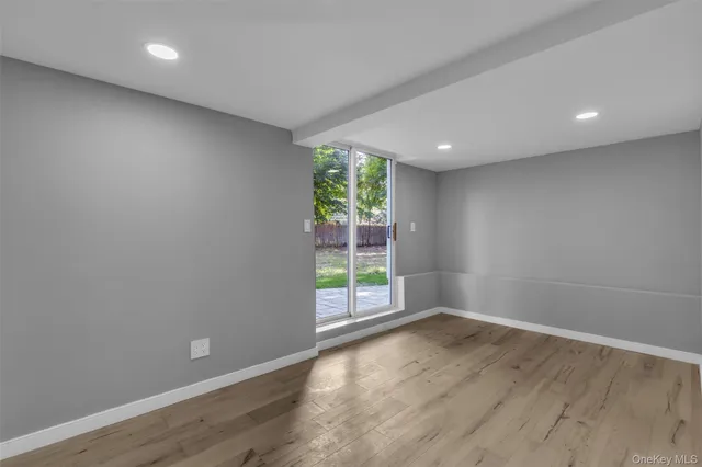 a view of a big room with wooden floor and windows